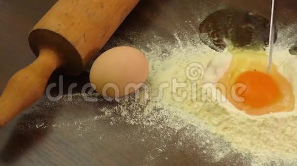 黑色木制背景上有鸡蛋黄的手工面粉视频的预览图