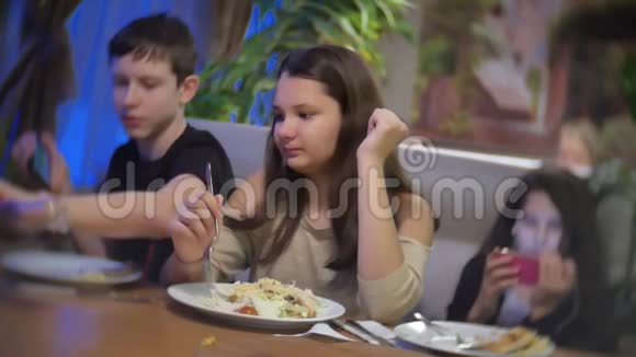 少女在快餐店吃沙拉一群朋友坐在咖啡馆的室内晚餐视频的预览图