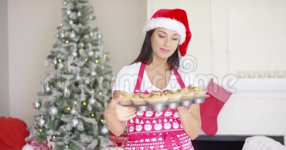 可爱的圣诞厨师炫耀她的纸杯蛋糕视频的预览图