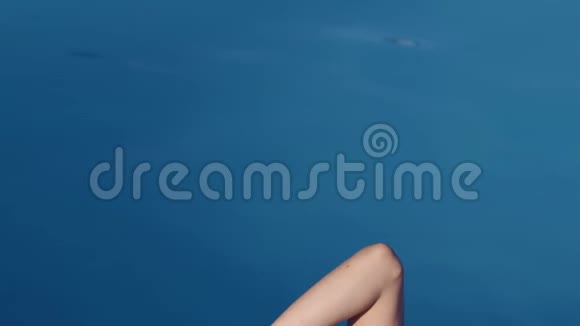 漂亮的女人躺在游泳池附近迷人的晒黑女孩躺在泳池边视频的预览图