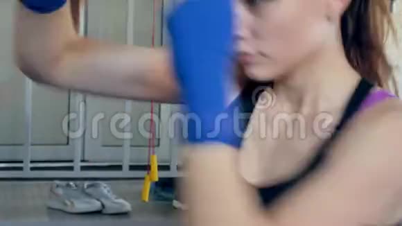 在健身室用橡皮筋进行漂亮的跆拳道女子训练拳打脚踢强壮有力适合身体的跆拳道视频的预览图