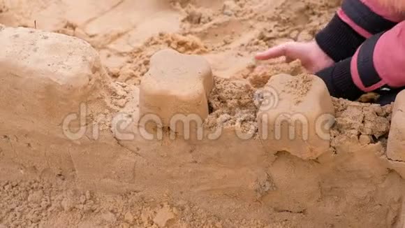 女孩在院子里玩沙子建造沙堡视频的预览图