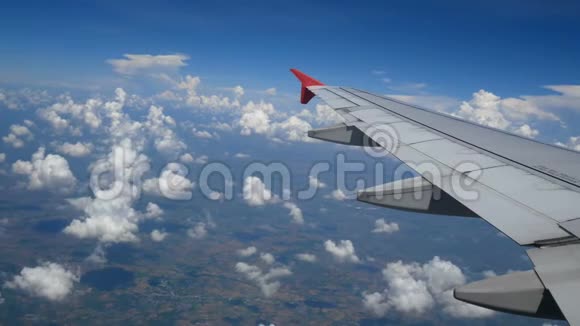 4K镜头乘飞机旅行通过飞机窗口的空中视野蓝天上的翼飞机和美丽的白云视频的预览图