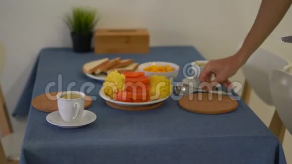 一个在厨房里为家人准备早餐的年轻人视频的预览图