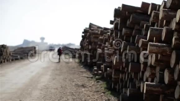 垃圾和卡车沿着堆积的原木在土路上行驶视频的预览图