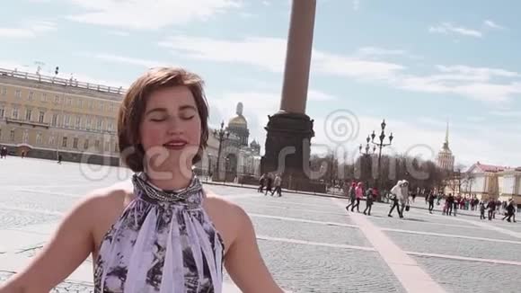 在圣彼得堡的皇宫广场唱着夏装的迷人女子视频的预览图