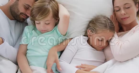 一家人睡在床上睡在舒适的家里4k视频的预览图