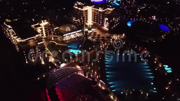 晚上在豪华度假酒店领土上鸟瞰录像酒店建筑群内部照明的夜景视频的预览图