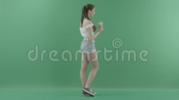 有魅力的年轻女性在绿色背景下喝鸡尾酒视频的预览图