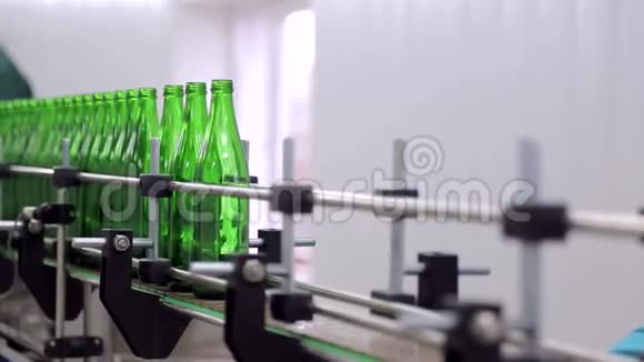 线的制水该员工将玻璃瓶放置在自动清洗和灌装瓶子的生产线上视频的预览图