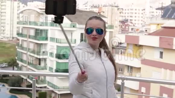 年轻快乐的女人用智能手机手机相机在屋顶上拍摄自己的肖像特写镜头高清19视频的预览图