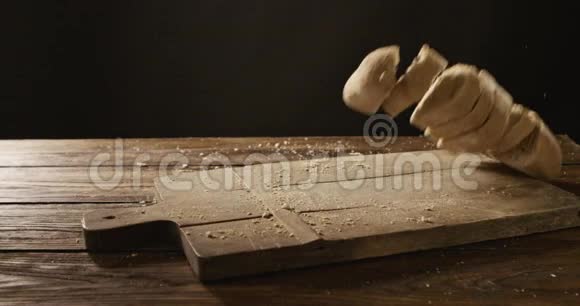 在一块砧板和一张木桌上一块块新鲜的面包掉了下来视频的预览图