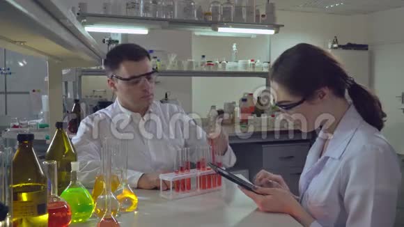 化学工程师拿着试管用液体与学生交谈视频的预览图