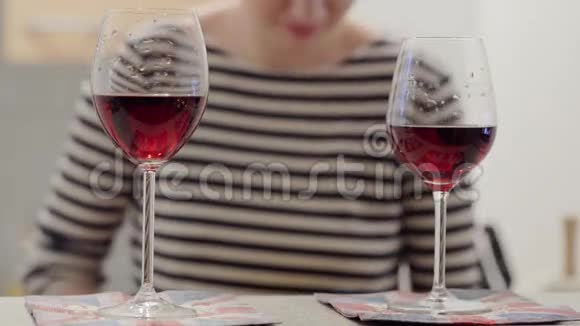两杯红酒和背景中穿条纹T恤的女孩视频的预览图