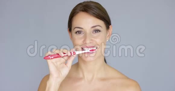 健康的年轻女人清洁她的牙齿视频的预览图