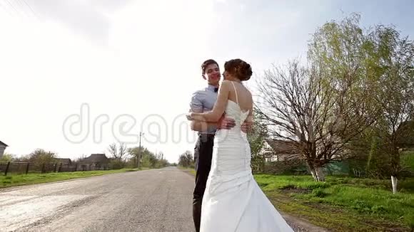 新娘和新郎拥抱在路上视频的预览图