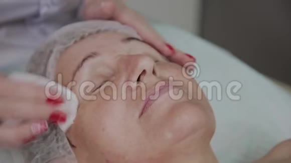 美容师在美容诊所为一名老年妇女洗脸视频的预览图
