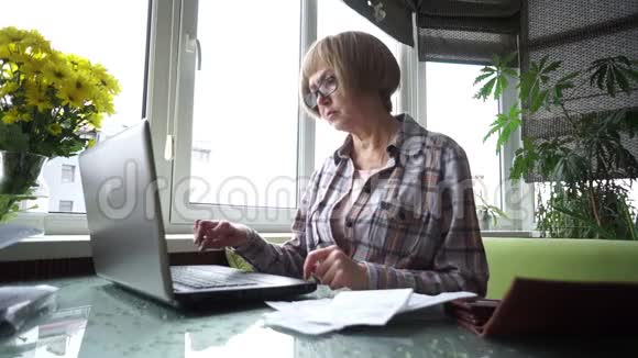 一个单身的高级女性养老金领取者在你的电脑上工作视频的预览图