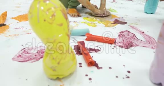 孩子们忙着用五颜六色的颜料覆盖她的身体视频的预览图
