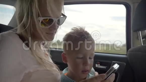 小孩在车里玩妈妈的智能手机视频的预览图