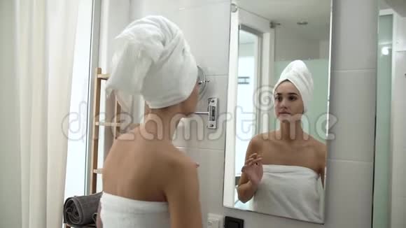 面部皮肤护理女人在浴室里涂抹护肤霜视频的预览图