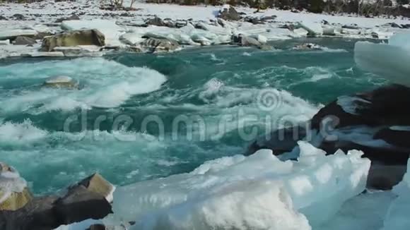 河水在春天解冻的冰中流动卡屯河阿尔泰俄罗斯视频的预览图