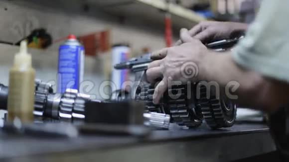 汽车修理工修理车库内的传动机构视频的预览图