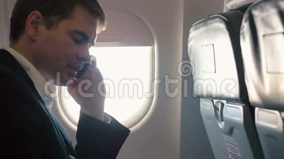 在飞机上打商务电话的年轻人视频的预览图