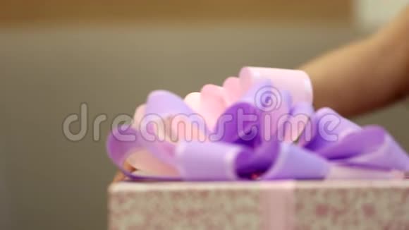 可爱快乐的小女孩孩子看起来拿着一个巨大的礼物盒包裹在紫色丝带蝴蝶结上视频的预览图