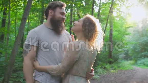 一对相爱的夫妇在绿色的夏天森林里视频的预览图