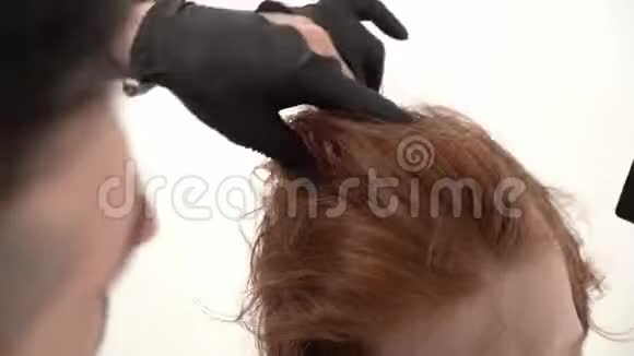 发型师理发师做一个时髦的发型年轻男人与红头发视频的预览图