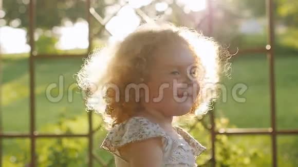 快乐的小女孩笑着夕阳在夕阳下卷曲的女孩视频的预览图