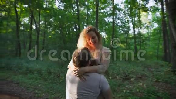 年轻人拥抱他的女朋友把她抬到森林里视频的预览图