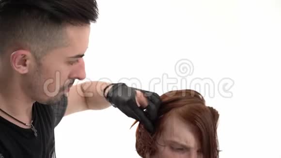 发型师理发师做一个时髦的发型年轻男人与红头发视频的预览图