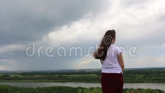 大灰云和大自然背景下的小女人视频的预览图