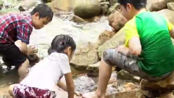 亚洲儿童在河里坐着玩视频的预览图