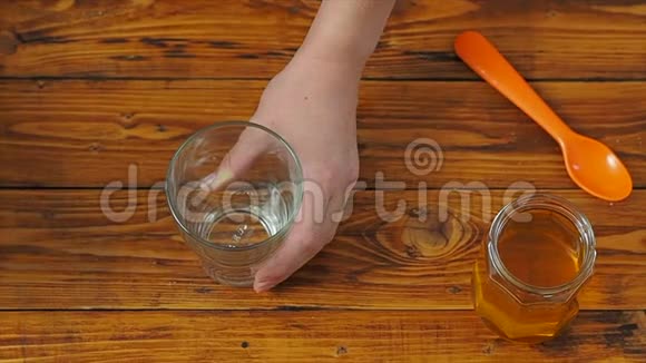 运动女孩把杏仁牛奶倒进厨房的玻璃杯里慢动作视频的预览图