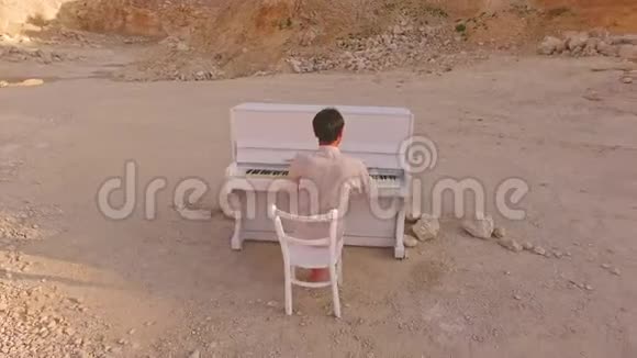年轻人在黄山和石头的背景下弹钢琴视频的预览图