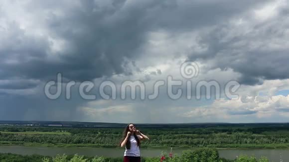 大灰云和大自然背景下的小女人视频的预览图