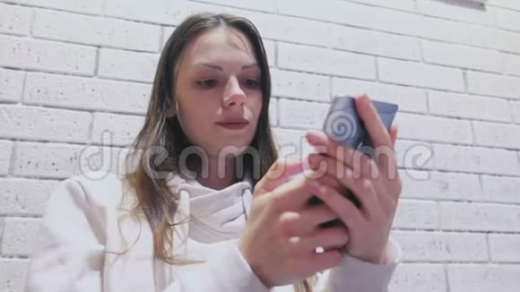 女人正在手机上输入一条信息坐在咖啡馆里等人视频的预览图
