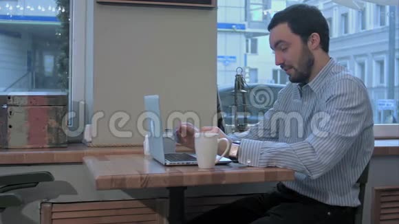 情感自由职业者带着笔记本电脑的人一大早就在咖啡馆打哈欠视频的预览图