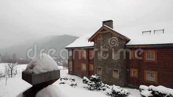 大雪时山村的木屋背景是针叶林落在原木上的雪视频的预览图