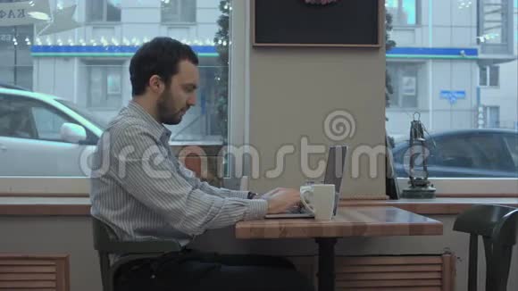 成功的年轻商人在咖啡馆里用笔记本电脑工作喝咖啡视频的预览图