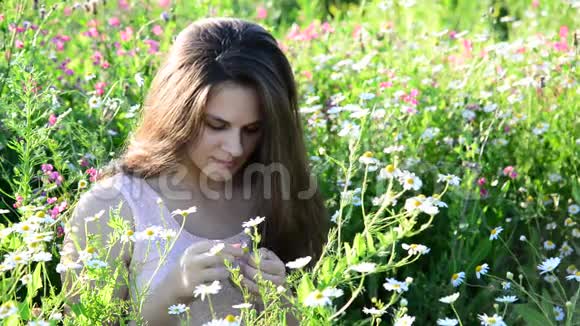 女孩在草地上的一朵花上讲述命运视频的预览图
