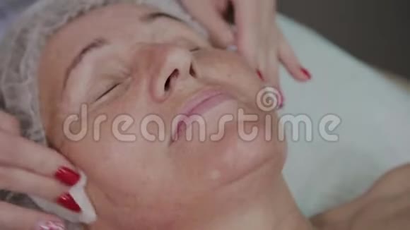美容师在美容诊所为一名老年妇女洗脸视频的预览图