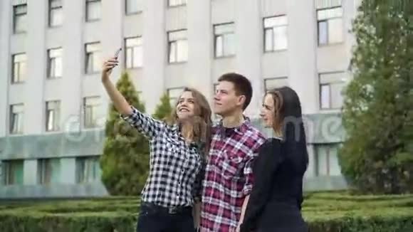 快乐快乐的朋友在大建筑背景上自拍视频的预览图