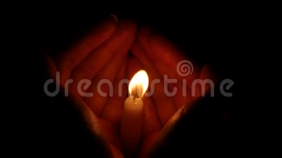 黑色背景下女性手中的蜡烛关门视频的预览图