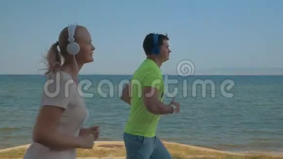 一对戴着耳机沿着海边慢跑视频的预览图