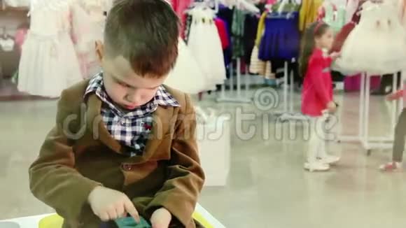 有智能手机的男孩在店里等着视频的预览图