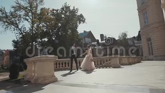 新婚夫妇走在历史宫殿里视频的预览图
